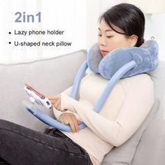 a woman sitting on top of a couch holding a remote control in her hand while wearing a neck pillow