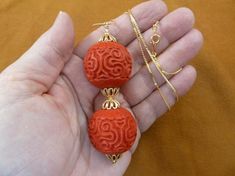 ( #J13-23)  You are bidding on a new CINNABAR BEADED pendant necklace, beads drilled top to bottom.TWO LARGE 30mm red cinnabar round beads, gold alloy caps and accent beads, 2-7/8” long; on 24” gold plated necklace with round closure.THIS IS EXACTLY THE ITEM YOU WOULD RECEIVE. For guy or gal, an awesome one-of-a-kind gift.WE SHIP WORLDWIDE! Other accepted payment: Credit card (Mastercard/Visa/Discover) inquire for details Traditional Red Carved Necklace, Brown Carved Round Beads Necklaces, Orange Hand-strung Jewelry With Round Beads, Ceremonial Large Red Beads, Penny Necklace, Round Carnelian Orange Beads, Shiny Earrings, Phoenix Pendant, Orange Amulet-style Jewelry With Large Beads