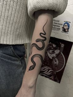 a woman with a snake tattoo on her arm