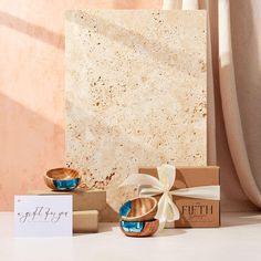 two wooden bowls sitting on top of a table next to a box with a bow