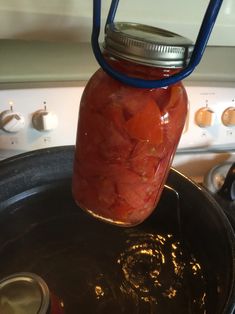 a jar filled with pickles sitting on top of a stove