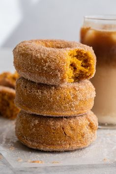 three donuts stacked on top of each other next to a cup of coffee