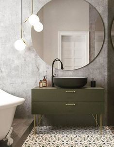 a bathroom with a round mirror above the sink and a bathtub in front of it