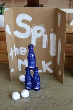 two blue bottles sitting next to each other in front of a cardboard box that says spin the milk