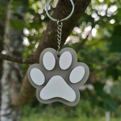 a dog paw shaped keychain hanging from a tree