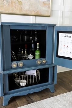 a blue cabinet with bottles and glasses in it