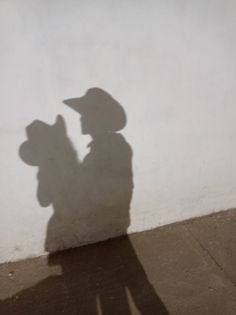 a shadow of a person with a hat on