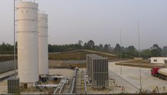 an industrial area with pipes and tanks on the ground