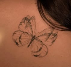 the back of a woman's neck with a butterfly tattoo on it