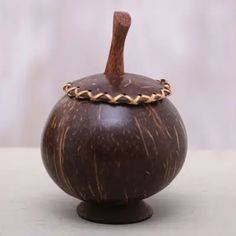 a small wooden vase with a handle on top of it's side, sitting on a table