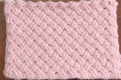 a pink crocheted dishcloth sitting on top of a wooden table