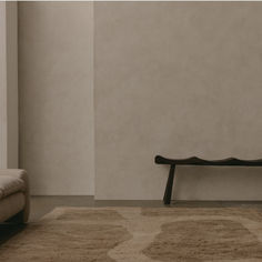 a wooden bench sitting on top of a carpeted floor next to a white wall