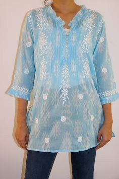 Introducing our Aztec Print Short Chikankari Kurta - a perfect blend of contemporary style and traditional craftsmanship. Made on super soft Cotton Mulmul Fabric with a Ruffle neckline, adorned with pleats and delicately crafted shell button loops, adds a touch of elegance to this chic piece.  Designed for both comfort and style, the kurta features side slits for ease of movement. Immerse yourself in the artistry of Chikan embroidery that graces every inch of this kurta, creating a captivating and timeless appeal.  Elevate your wardrobe with this unique fusion of Aztec prints and intricate Chikankari detailing - a statement of refined fashion for any occasion. Length - 28-30 inches Size -  S - fits bust 34 M - fits bust 36 L - fits bust 38 XL - fits bust 40 0X - fits bust 42 1X - fits bust Summer Blue Kurta With Embroidered Neckline, Blue Summer Kurta With Embroidered Neckline, Elegant Spring Straight Kurta Tops, Elegant Embroidered Neckline Tunic For Summer, Elegant Summer Tunic With Embroidered Neckline, Elegant Straight Kurta Tunic For Summer, Elegant Straight Kurta Tops For Summer, Elegant Summer Straight Kurta Tunic, Spring Straight Kurta Blouse With Embroidered Neckline