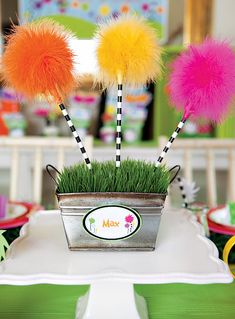 there are some fake grass in a pot with pom - poms on it