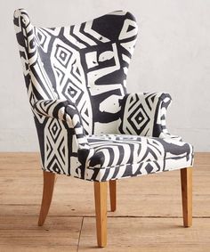 a black and white patterned chair sitting on top of a wooden floor