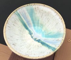 a white and blue bowl sitting on top of a wooden table