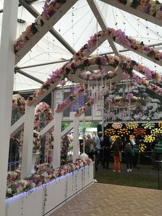 the inside of a building decorated with flowers and hanging chandeliers for an event