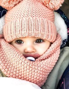 a small child wearing a knitted hat and scarf