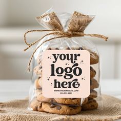 a clear bag filled with cookies sitting on top of a table next to a sign that says your logo here