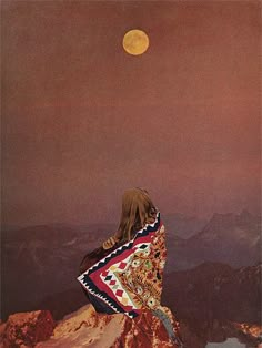 a woman sitting on top of a mountain looking at the sky with a full moon in the background