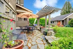 an outdoor patio with table, chairs and umbrella