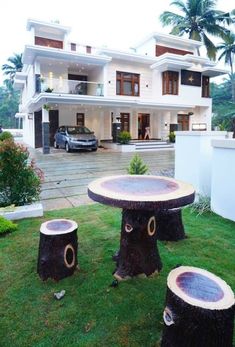 two tree stump tables in front of a house