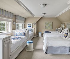 there are three beds in this room with blue and white decor