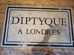 there is a sign that says diptyque a londres on the wall