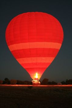 a large hot air balloon is lit up at night