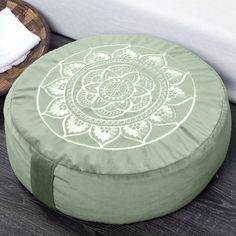 a green round floor pillow sitting on top of a wooden table