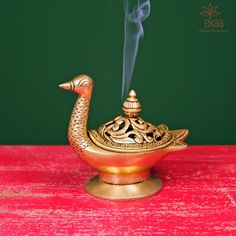 "What's Included Brass Dhoop Burner Product Description Purify your homes with the holy fragrance from Loban Lamp. When one comes in contact with the 'loban' incense, the individual feels relaxed and stress-free, with a clear mind. It also keeps insects away and fills the house with positive energy. It is easy to hold for doing \"Dhuni\" (Cleaning the air of your house). It can also be used as \"Akhand Diya\". It can be used for inserting loban, bakhoor, samarni dhoop incense sticks or as a diff Incense Burner Brass, Brass Urli Stand, Brass Swan, Brass Interior, Pooja Room Design, Goddess Decor, Puja Room, Clear Mind, Pooja Rooms