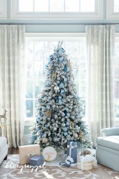 a living room with a christmas tree in the corner and presents on the floor next to it