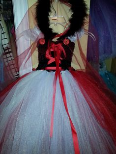 a close up of a dress on a mannequin with a red ribbon around it