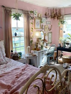 a bedroom with pink walls and lots of pictures hanging on the wall above the bed