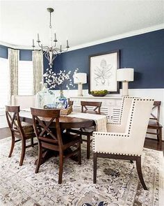 a dining room with blue walls and white furniture