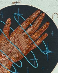 a hand is shown in an embroidery hoop