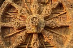 an intricately carved wheel on the side of a building