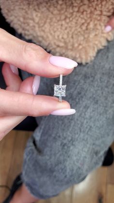 a woman's hand holding an engagement ring