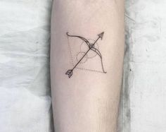 a small arrow tattoo on the leg