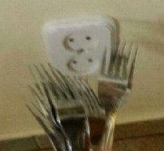 there are forks and silverware in a cup with a smiley face drawn on it