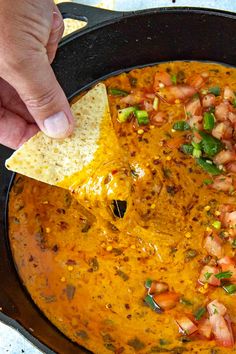 a tortilla chip being dipped with salsa