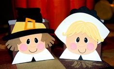 two paper dolls with hats on their heads