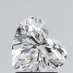 a heart shaped diamond sitting on top of a black stand in front of a gray background