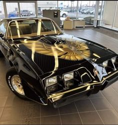 a black and gold pontiac car in a showroom