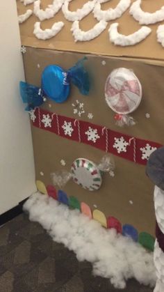 an office cubicle decorated for christmas with snowmen, candy canes and decorations