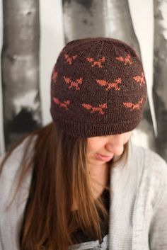 a woman wearing a knitted hat with red deers on the front and back