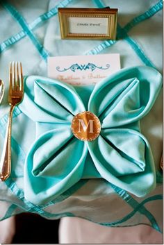 an image of a table setting with goldware and napkins on it's place card holder