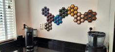 a coffee maker sitting on top of a counter next to a wall mounted art piece