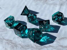 five green dices sitting on top of a white table covered in frosty material