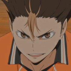 an anime character with brown hair and blue eyes looks at the camera while wearing an orange shirt